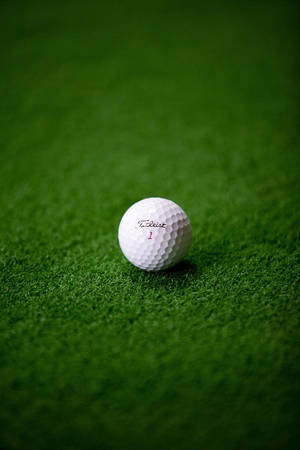 綠色草皮上的白色高爾夫球 — 白色 iPhone 壁紙