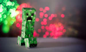 綠色Minecraft爬行者公仔，背景有色彩繽紛的模糊燈光。 — 我的世界 壁紙