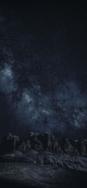 在繁星點點的天空下，黑暗的山脈，銀河清晰可見。 — Galaxy A36 壁紙