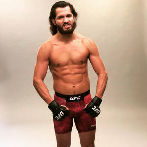 一個肌肉發達、留鬍鬚的UFC拳手，穿著紅色短褲和黑色手套。 — 運動 壁紙