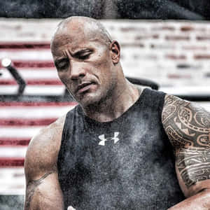 一個在健身房穿著 Under Armour 背心、汗流浹背的紋身男子。