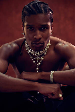 一個梳著辮子、佩戴多層珍珠首飾的男人直視鏡頭。 — ASAP Rocky 壁紙
