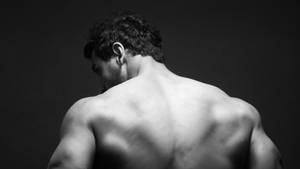 一個肌肉發達的男人從背後觀看的黑白工作室肖像。 — 傑基·羅賓森 壁紙