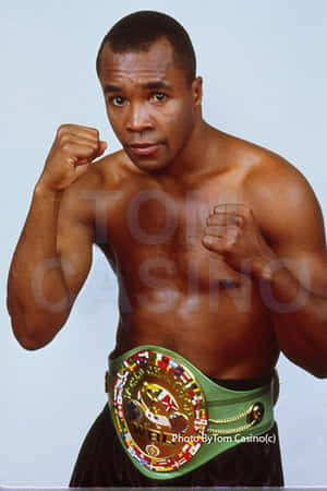 一個赤裸上身的黑人男性拳擊手以戰鬥姿勢佩戴冠軍腰帶。 — 冠軍 壁紙