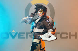Overwatch角色身穿棕色和橙色裝備，手持發光武器擺姿勢。 — MacBook Pro 16 壁紙