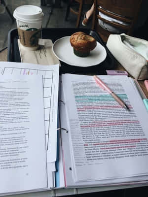 打開的教科書、咖啡杯和筆放在木桌上用於學習。 — 讀書 壁紙