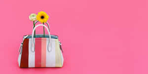 一個條紋手提包，花朵從粉紅色背景中伸出。 — Kate spade 壁紙