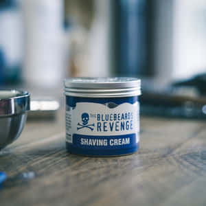 Bluebeards Revenge 刮鬍膏罐放在木質檯面上，旁邊有金屬碗 — 1:1 壁紙