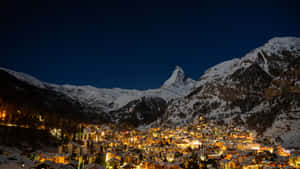 夜間燈光照亮的雪山村莊，背景是馬特洪峰。 — 瑞士 壁紙