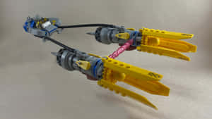 一個帶有黃色機翼和灰色引擎的LEGO太空船模型。