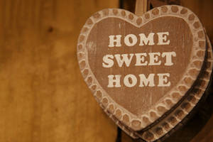 木製心形標牌，上面寫著 home sweet home，掛在木牆上。 — 甜蜜的家 壁紙