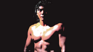 一個濕髮的肌肉男，在黑色背景下被聚光燈照亮。 — 櫻島麻衣 壁紙