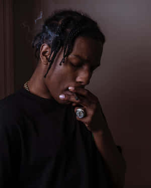 辮子男人在室內拿著香煙呼出煙霧。 — ASAP Rocky 壁紙