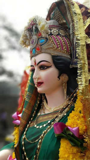 一個裝飾過的印度教女神雕像，穿著綠色服裝和金色珠寶。 — Maa Durga 壁紙