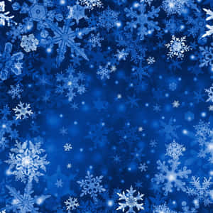 發光的雪花在深藍色的冬夜天空中飄浮。 — 美學藍色 iPhone 壁紙