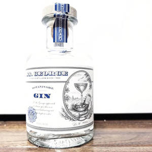 St George Botanivore Gin 酒瓶放在木質表面上，背景為白色。 — 植物美學 壁紙
