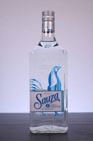 深色木質表面上的 Sauza Silver Tequila 酒瓶，灰色背景 — Huawei MatePad Edge 壁紙