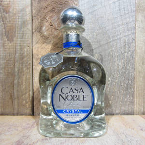 Casa Noble Crystal Blanco龍舌蘭酒瓶在木質表面上，木頭背景。 — 瑪琳娜與鑽石樂團 壁紙