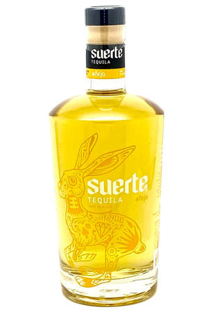 Suerte Añejo龍舌蘭酒瓶，帶有兔子設計和金色液體。 — Huawei MatePad 壁紙