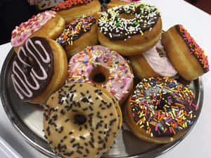 各式糖霜甜甜圈拼盤，配有彩色糖粒和巧克力醬。 — Dunkin Donuts 壁紙