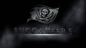 黑暗煙霧中，海盜旗上有骷髏頭和劍，位於Buccaneers字樣上方。 — 黑色 壁紙