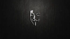 在深色紋理皮革背景上的銀色蓋伊·福克斯面具 — 駭客面具 壁紙