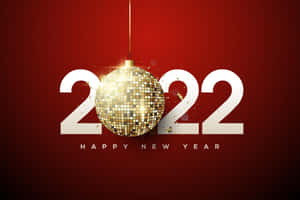 金色 disco 球懸浮在 2022 年上方，紅色背景上帶有 'Happy New Year' 文字。 — MacBook Air M3 壁紙