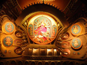金色神龕，中央印度教神祇與惡魔戰鬥，周圍有神祇獎章。 — Maa Durga 壁紙