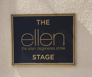 安裝在有紋理牆上、陽光照射下的The Ellen DeGeneres Show Stage標誌。 — 艾倫·狄珍妮 壁紙