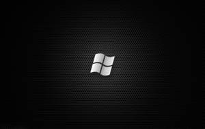 銀色Windows標誌在黑色穿孔金屬背景上。