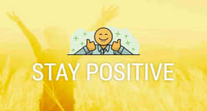 卡通人物在金色麥田上豎起大拇指，帶有'STAY POSITIVE'文字。 — 正向 壁紙