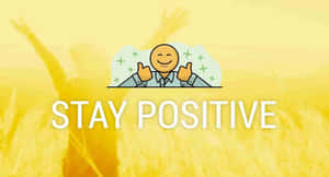一個微笑的卡通人物豎起兩個大拇指，上面有STAY POSITIVE字樣，背景是金色麥田。 — 正向 壁紙