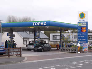 一個陰天，Topaz 加油站有汽車在藍色遮篷下加油。 — 加油站 壁紙