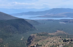 山谷橄欖樹林和海岸小鎮的全景 晴朗的天空下 — 山脈 壁紙