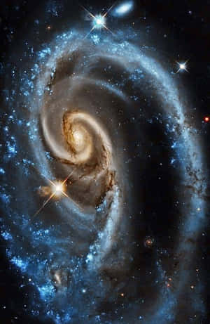 一個在深空中帶有藍色旋臂和明亮恆星的螺旋星系。 — 星際效應 壁紙