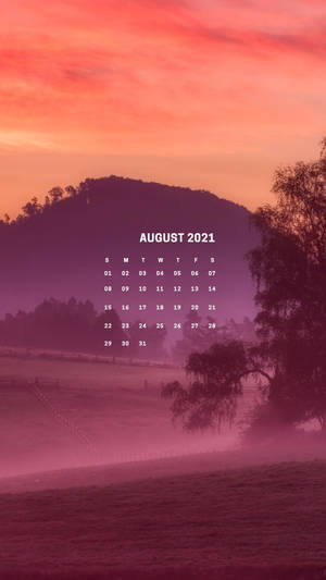 2021年8月日曆，置於有山丘和樹木的霧氣日出景觀上。 — 八月 壁紙
