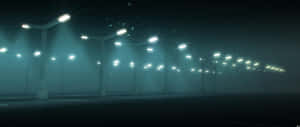 霧氣瀰漫的空蕩停車場中，一排排發光的街燈。 — 街頭 壁紙