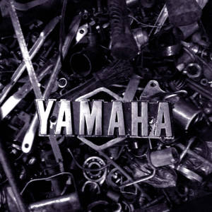 一個Yamaha標誌被散落的黑白機車引擎零件包圍。 — 巴布風機車 壁紙