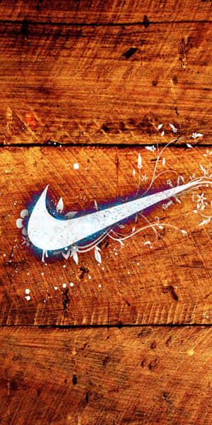 在質樸木質背景上帶有花卉設計的Nike標誌 — Pixel 3 壁紙