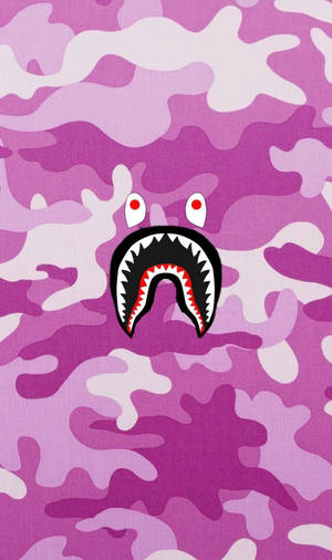 紫色迷彩背景，帶有卡通鯊魚臉。 — BAPE 標誌 壁紙