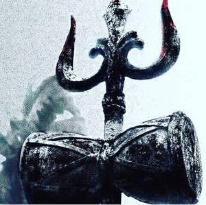 一個三叉戟和沙漏，帶有紅色亮點，背景朦朧。 — 濕婆 壁紙