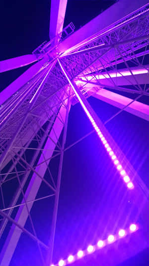 一個發光的紫色摩天輪高聳在夜空中。 — 夜晚 壁紙