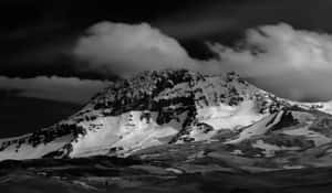 黑白暴風雨天空下的積雪山峰。 — 山景 壁紙