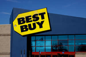 Best Buy商店外觀，黃色招牌配藍色外牆，天空晴朗。 — 最佳購買 壁紙