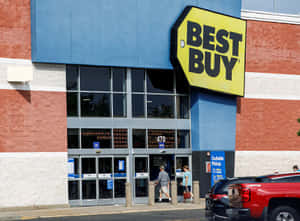 Best Buy商店入口，有顧客進入，外面停著一輛紅色貨車。 — 最佳購買 壁紙
