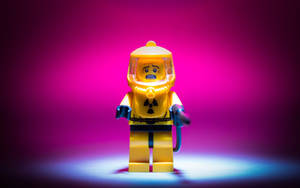 黃色LEGO人偶穿著防護衣在聚光燈下，洋紅色背景 — 樂高旋風忍者 壁紙