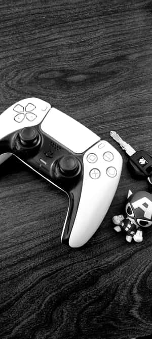 PlayStation 5手把連同鑰匙圈和美國隊長人偶在木質表面上。 — Pixel 9 壁紙