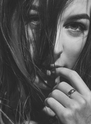 女性咬手指的特寫，帶有深色頭髮和戒指。 — 害羞 壁紙