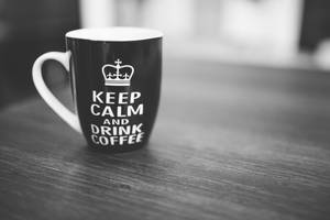 黑色馬克杯，帶皇冠和keep calm and drink coffee字樣，在木桌上。 — 平靜 壁紙