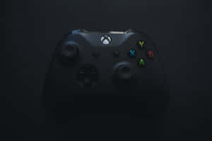 黑色Xbox手把在深色背景上帶有發光按鈕 — 酷炫遊戲 壁紙